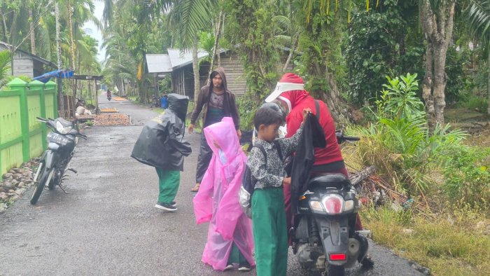 Perjuangan Orang Tua Antar Anak ke Madrasah Saat Hujan